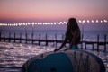 yolo-board-girl-standing-at-beach-hands-on-sup-at-dusk.0446451c8106862c5dc44aa299a497b8.jpg