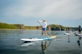 Pompowane deski SUP Gladiator Elite - duża grupa osób na morzu_half.webp