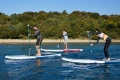 deska sup Gladiator Origin 10.8 – transport i użytkowanie nad wodą, osoby niosące deskę SUP na plaży