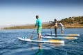 Deski SUP Gladiator Elite 2026 – testy na wodzie, trzy osoby wiosłują, ujęcie z boku