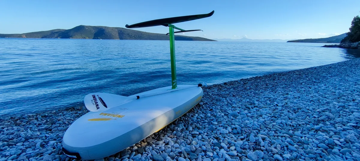 Deska Indiana z foilem na kamienistej plaży